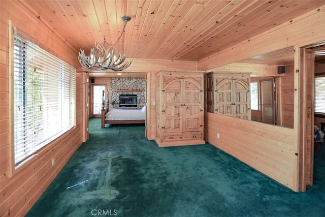 unfurnished bedroom featuring wooden ceiling, an inviting chandelier, wooden walls, and carpet