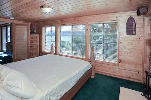 carpeted bedroom featuring wood walls and wooden ceiling