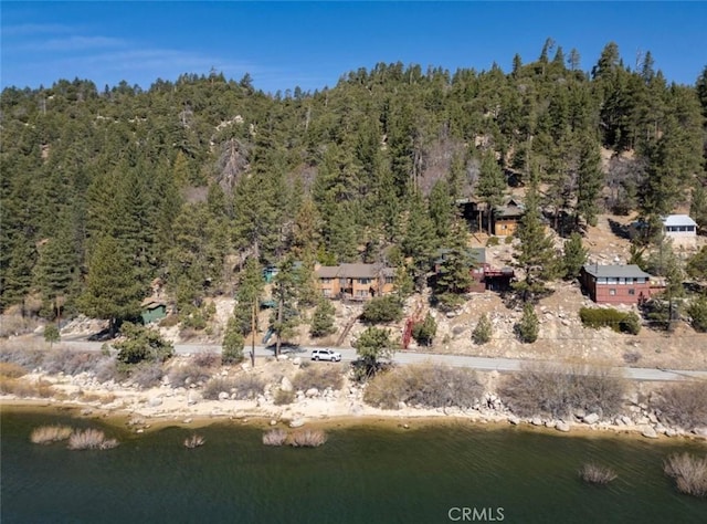 aerial view with a wooded view and a water view