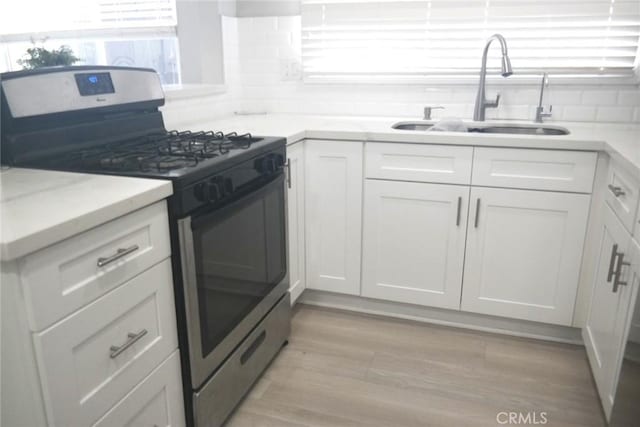 18214 Los Palacios Dr, Rowland Heights, CA 91748 - kitchen featuring white cabinetry, a sink, decorative backsplash, and stainless steel gas range oven
