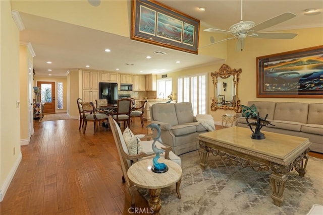 living room featuring recessed lighting, wood finished floors, a wealth of natural light, ornamental molding, and a ceiling fan