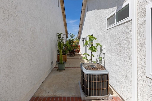 view of side of property featuring stucco siding and central AC unit