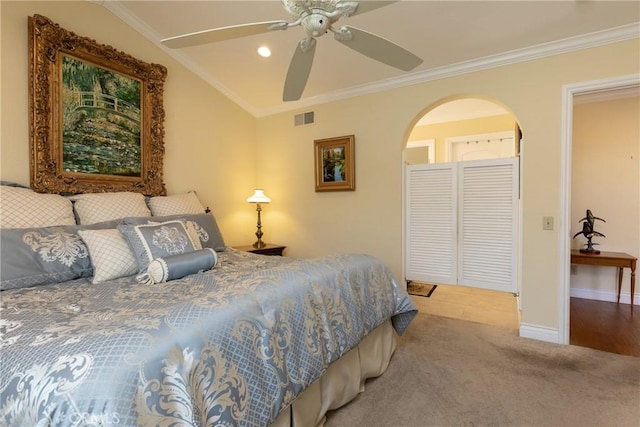 carpeted bedroom featuring ornamental molding, arched walkways, visible vents, and baseboards