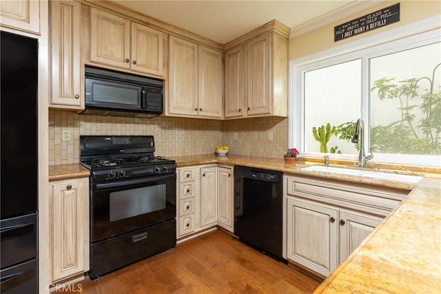 kitchen featuring decorative backsplash, light countertops, black appliances, a sink, and dark wood-type flooring