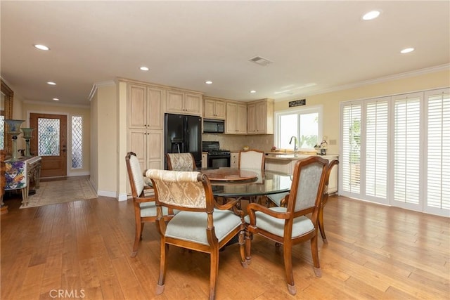 dining area featuring visible vents, light wood-style floors, baseboards, recessed lighting, and ornamental molding