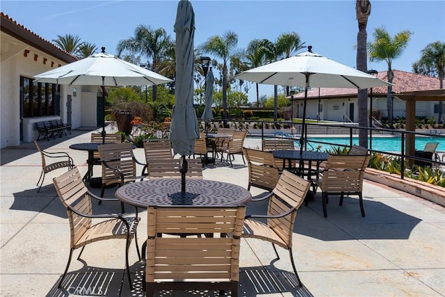 view of patio / terrace featuring fence and a community pool