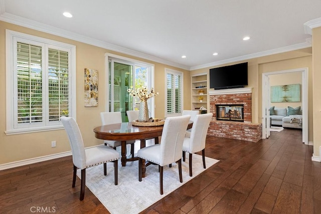 dining room featuring baseboards, ornamental molding, a brick fireplace, and dark wood-style flooring