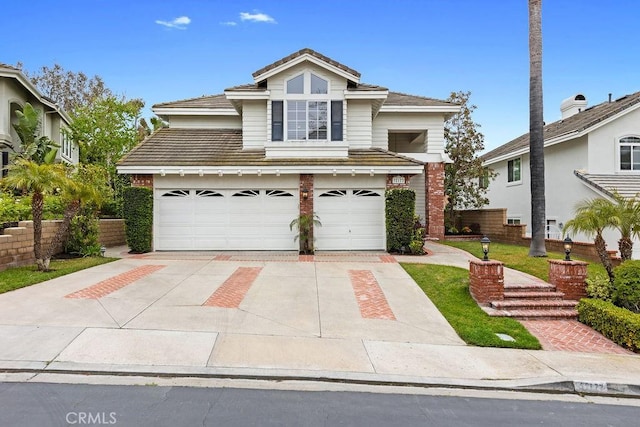 traditional-style home featuring a garage, driveway, and a tile roof