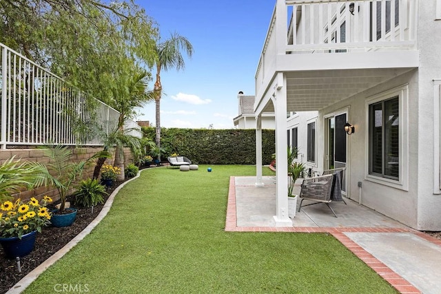 view of yard with a fenced backyard, a patio area, and a balcony