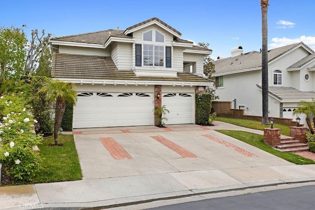 traditional home featuring an attached garage, a tile roof, and concrete driveway