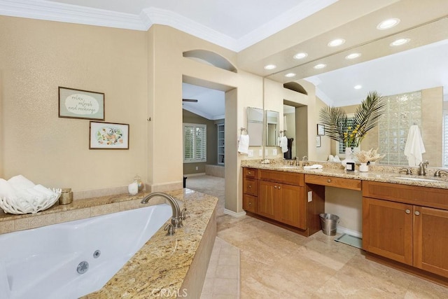 bathroom featuring double vanity, ornamental molding, a tub with jets, and a sink