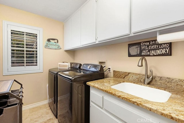 laundry room featuring baseboards, a sink, cabinet space, and washing machine and clothes dryer