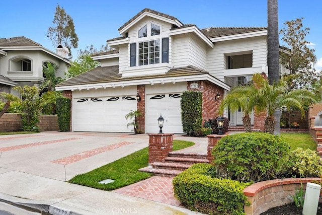 traditional-style home featuring an attached garage, driveway, and brick siding