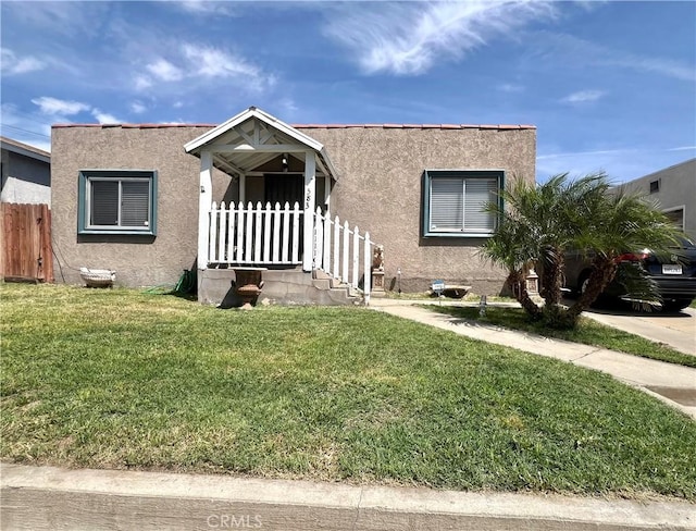 583 W G St, Colton, CA 92324 - bungalow-style house with a front lawn, stucco siding, and fence