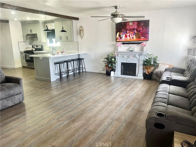 583 W G St, Colton, CA 92324 - living room with a ceiling fan, baseboards, wood finished floors, and a fireplace