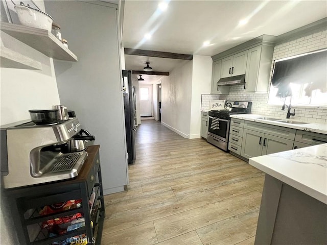 583 W G St, Colton, CA 92324 - kitchen with a sink, light wood-style floors, under cabinet range hood, and stainless steel gas stove