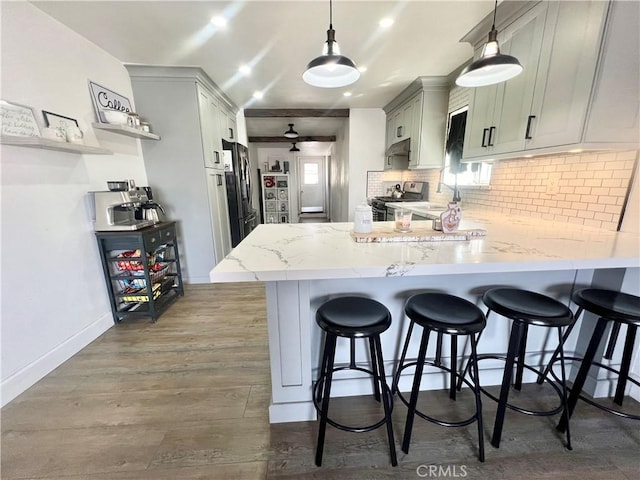 583 W G St, Colton, CA 92324 - kitchen with freestanding refrigerator, decorative backsplash, a peninsula, stainless steel gas stove, and baseboards
