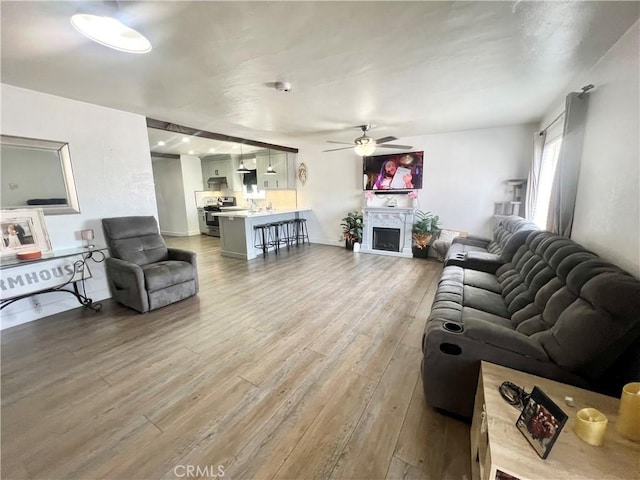 583 W G St, Colton, CA 92324 - living room with baseboards, ceiling fan, wood finished floors, and a fireplace