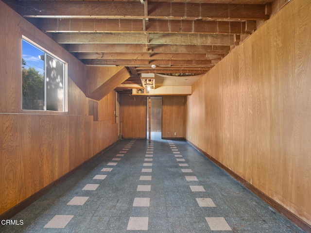 below grade area featuring wooden walls and dark floors