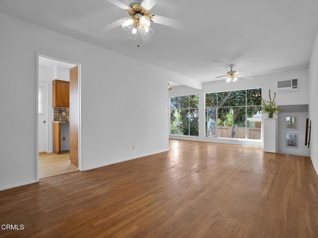 unfurnished living room with a ceiling fan, baseboards, wood finished floors, and a wall mounted air conditioner