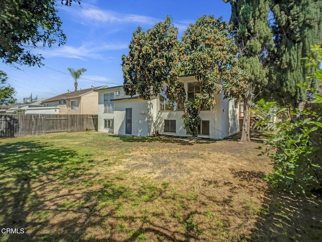 966 E Edgecomb St, Covina, CA 91724 - rear view of house featuring a lawn, stucco siding, and fence