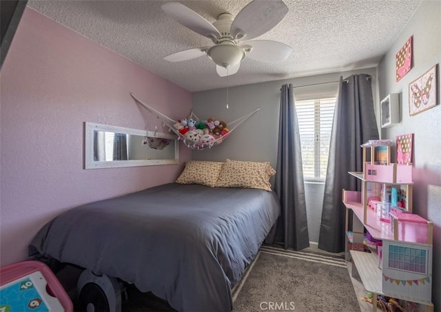 bedroom featuring ceiling fan, a textured ceiling, and carpet flooring