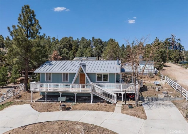 back of property with a standing seam roof, a porch, and metal roof