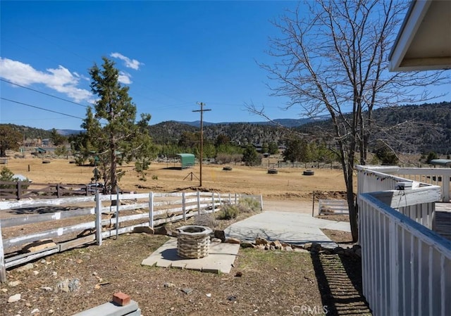 view of yard featuring a mountain view, fence, and a rural view