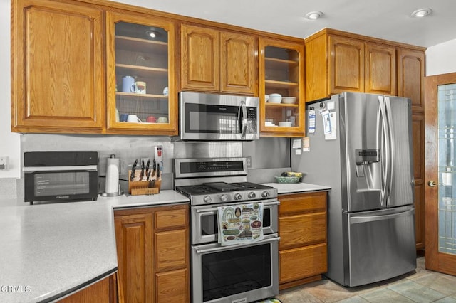 1213 Doris Ave, Oxnard, CA 93030 - kitchen featuring appliances with stainless steel finishes, brown cabinets, light countertops, glass insert cabinets, and recessed lighting