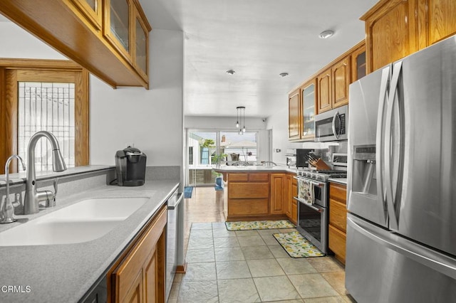 1213 Doris Ave, Oxnard, CA 93030 - kitchen featuring appliances with stainless steel finishes, a sink, a peninsula, and brown cabinetry