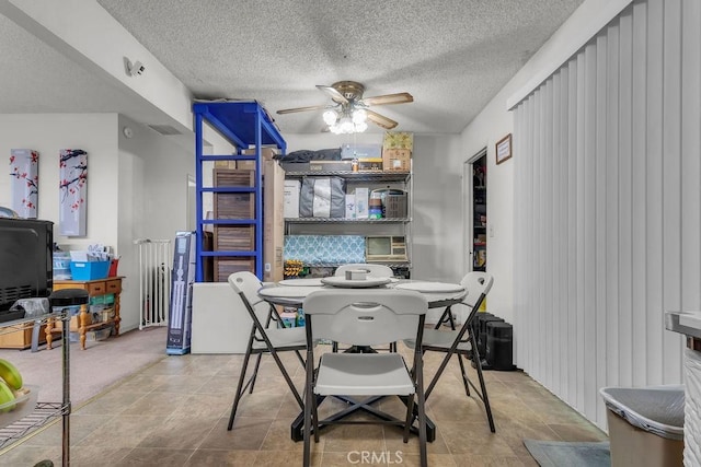 dining room featuring a ceiling fan and a textured ceiling