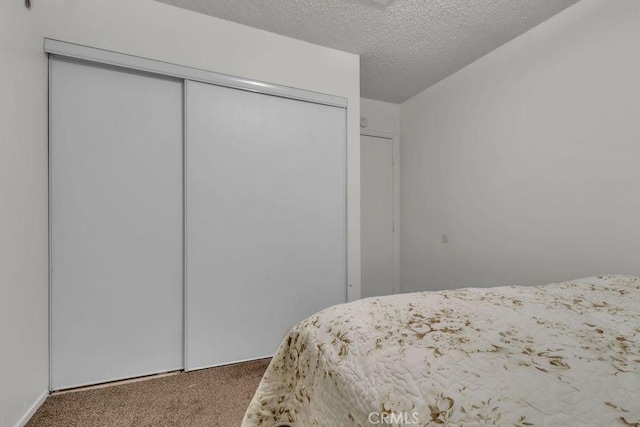 bedroom with a closet, carpet, and a textured ceiling