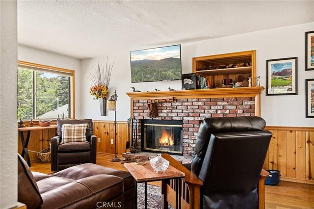 32991 Canyon Dr, Green Valley Lake, CA 92341 - living area with wainscoting, wood finished floors, wood walls, and a brick fireplace