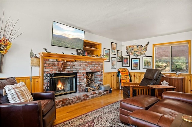 32991 Canyon Dr, Green Valley Lake, CA 92341 - living area featuring wood walls, wood finished floors, a wainscoted wall, and a brick fireplace