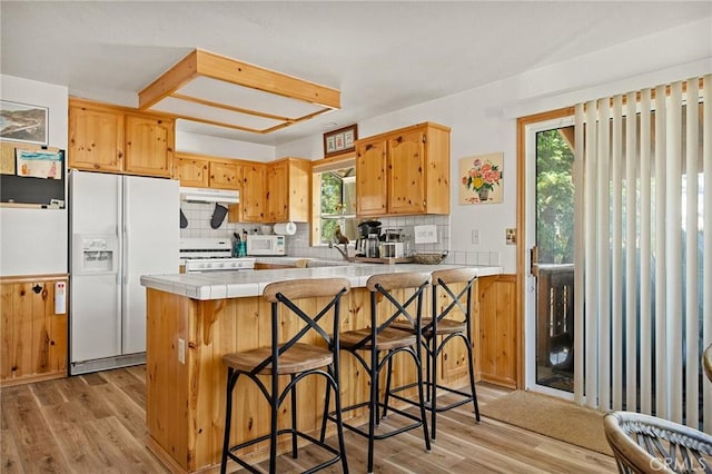 32991 Canyon Dr, Green Valley Lake, CA 92341 - kitchen featuring plenty of natural light, light wood-style floors, under cabinet range hood, and white appliances