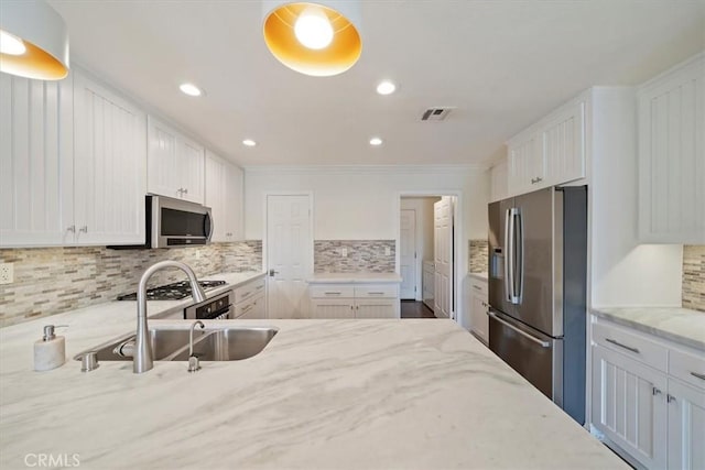 1616 Cormorant Dr, Carlsbad, CA 92011 - kitchen featuring appliances with stainless steel finishes, a sink, light stone countertops, white cabinets, and decorative backsplash