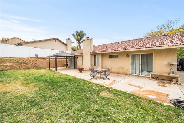 6932 Sundown Dr, Jurupa Valley, CA 92509 - back of property featuring a yard, a tiled roof, a gazebo, stucco siding, and fence