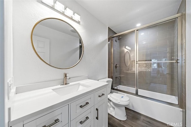 701 Black Oak Cir, Corona, CA 92881 - full bath featuring wood finished floors, vanity, toilet, shower / bath combination with glass door, and a textured wall