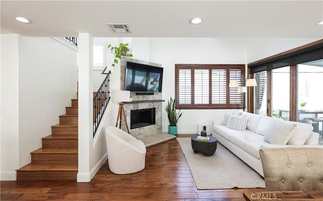 living area featuring baseboards, plenty of natural light, and stairway