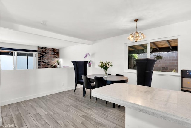 dining space with light wood finished floors, a wealth of natural light, and a notable chandelier