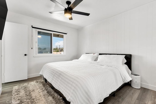 bedroom with baseboards, a ceiling fan, and wood finished floors