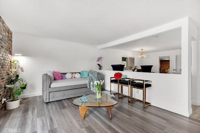 living room featuring baseboards, a chandelier, and wood finished floors