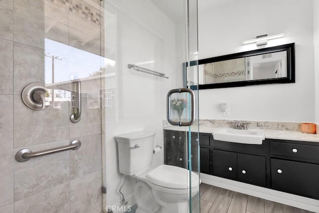 bathroom with vanity, toilet, and a shower stall