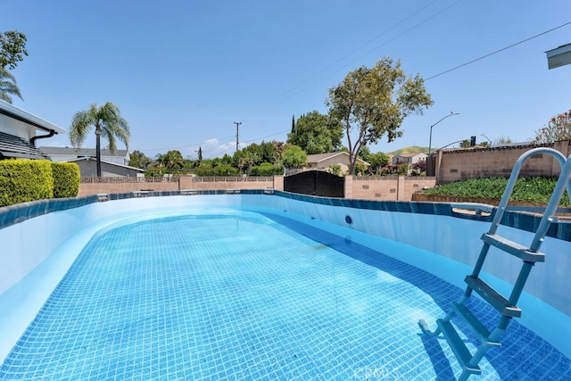 view of swimming pool featuring a fenced backyard and a fenced in pool