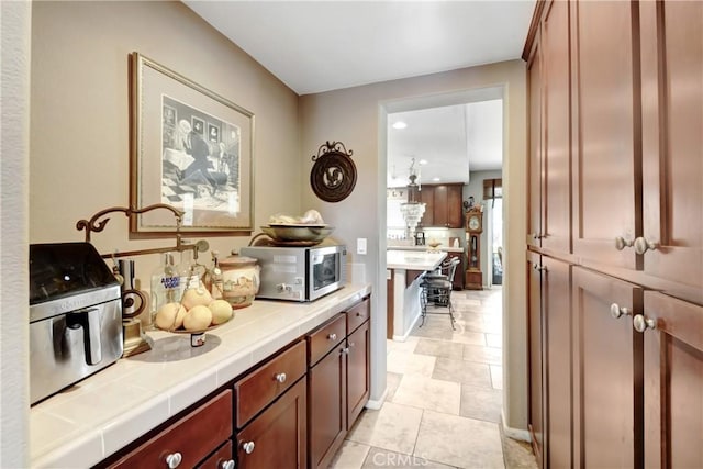 34440 Fawn Ridge Pl, Yucaipa, CA 92399 - kitchen with tile counters, stainless steel microwave, and light tile patterned floors