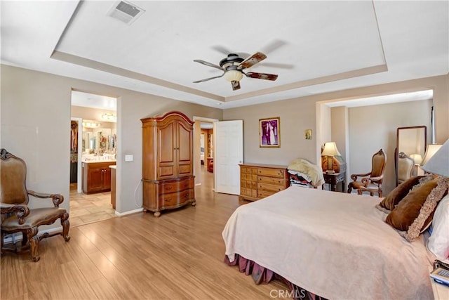 34440 Fawn Ridge Pl, Yucaipa, CA 92399 - bedroom with a tray ceiling, light wood-style floors, baseboards, and connected bathroom
