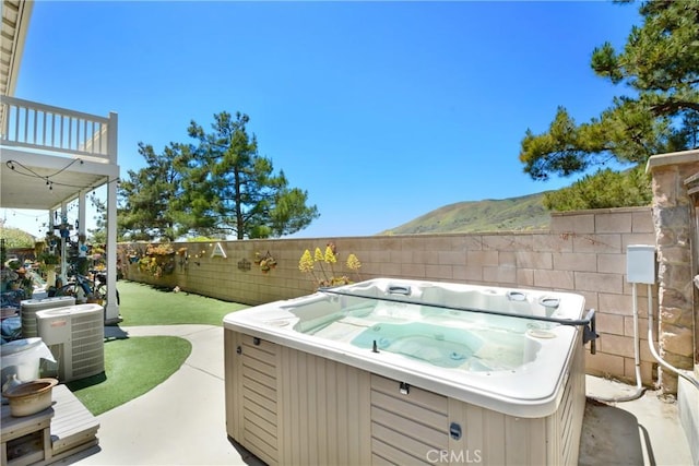 34440 Fawn Ridge Pl, Yucaipa, CA 92399 - view of patio / terrace with a hot tub, a fenced backyard, a mountain view, and central AC