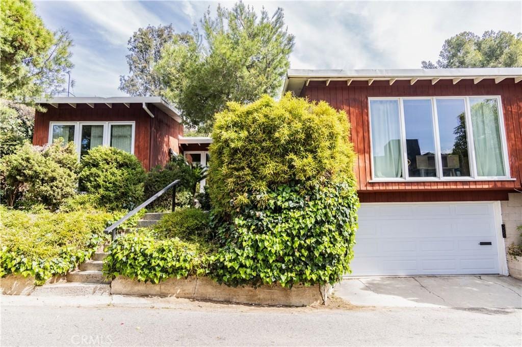 3288 Velma Dr, Los Angeles, CA 90068 - view of property hidden behind natural elements with an attached garage and driveway