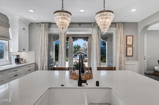 20752 Veneto Way, Porter Ranch, CA 91326 - kitchen with a chandelier, arched walkways, hanging light fixtures, tasteful backsplash, and recessed lighting