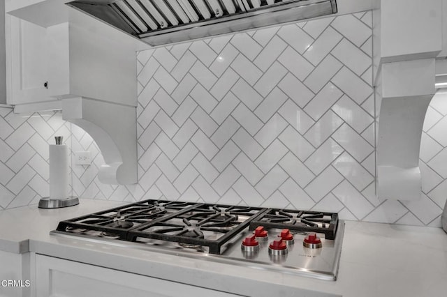 20752 Veneto Way, Porter Ranch, CA 91326 - kitchen with stainless steel gas stovetop, custom exhaust hood, light countertops, white cabinetry, and backsplash